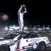 a jockey race car has a man standing on top of it