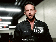 a man wearing a jacket that says ron mike tyson