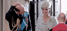 a man is kissing a woman on the forehead while standing next to a woman .