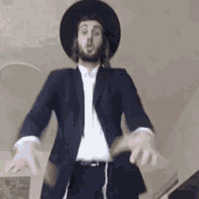 a jewish man in a suit and hat is dancing in a room .