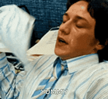 a man in a striped shirt and tie is saying yummy .