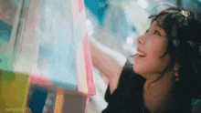 a woman is smiling while looking at a display of candy in a store .
