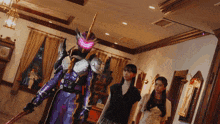 a man in a purple armor is holding a sword and standing next to two women