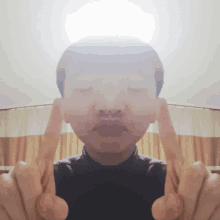 a man making a face with his eyes closed and his fingers up