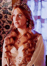 a woman wearing a tiara and a white dress is standing in a room .
