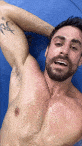 a shirtless man with a beard has a tattoo on his arm that says ' # '