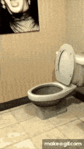 a toilet in a bathroom with a picture of a man on the wall