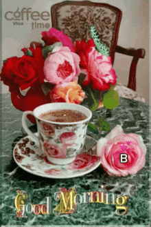 a cup of coffee sits on a saucer next to a vase of flowers