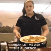a woman in a black shirt is holding a plate of food and says " i mean let me ask the audience "