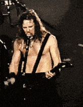 a man singing into a microphone while playing a guitar