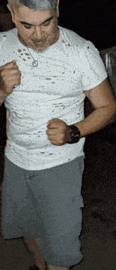a man wearing a white t-shirt and grey shorts