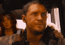 a man and a woman are sitting in a vehicle and the man is smiling