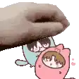 a hand is holding a cartoon character in a pink cat costume .