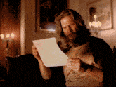 a man smoking a cigarette while reading a letter