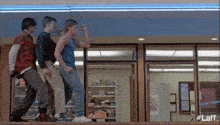 a group of young men are dancing in front of a store with a sign that says pizza hut