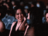 two women are laughing in a dark room and the word film is on the bottom left