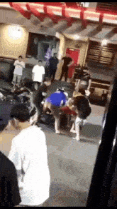 a group of people are standing in a room fighting each other .