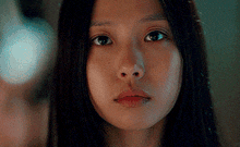 a close up of a woman 's face with a serious look on her face
