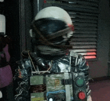 a person wearing a helmet and a vest with a red button that says " gas "