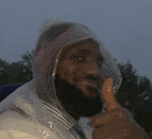 a man wearing a plastic bag on his head gives a thumbs up