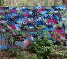 a wall covered in graffiti including the letters rb