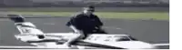 a man is riding on the back of a small airplane with the letters lx on it