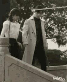 a man and a woman are walking down stairs .