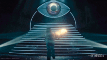 a woman stands in front of a large eye and stairs with odessa written on the bottom