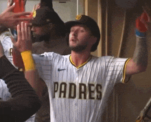 a man wearing a padres jersey is giving a high five