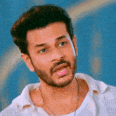 a man with a beard is wearing a white shirt
