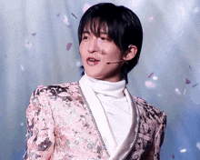 a young man wearing a pink jacket and white turtleneck