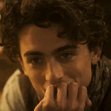 a close up of a young man 's face with his hand on his mouth
