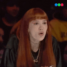 a woman with red hair is wearing a black shirt and a necklace that has the word barbie on it