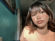 a girl with a fringe is wearing a pink shirt