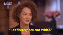 a woman with curly hair is smiling and saying `` i definitely am not white '' .
