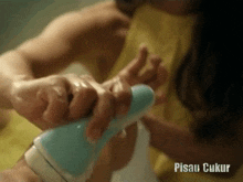 a close up of a person shaving another person 's hand with the words pisau ukur below it