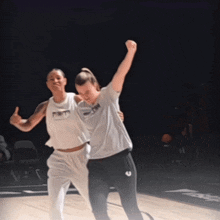 two female basketball players one wearing a shirt that says ' nl ' on it