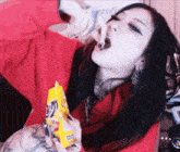 a woman in a red shirt is eating a bag of m & ms