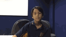 a young boy in a school uniform is sitting at a table .
