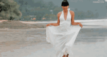 a woman in a white dress is walking on a beach with yourtype written on the bottom