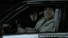 a man in a tuxedo and bow tie is driving a car at night .