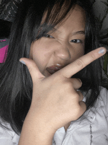 a young girl making a funny face with her fingers