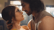 a man and a woman are kissing with glasses on .