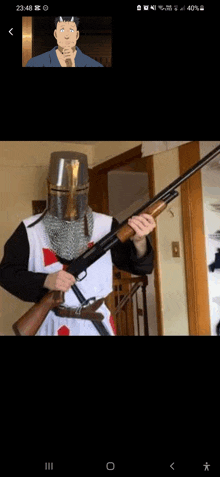 a man in a knight 's helmet is holding a shotgun