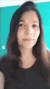 a close up of a woman 's face with a blue wall behind her