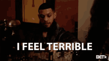 a man with a beard says i feel terrible while holding a glass
