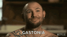 a man with a beard and tattoos is smiling and says gastonia on the screen