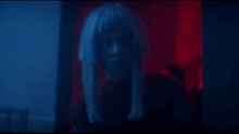 a close up of a woman 's face in a dark room with blue lights