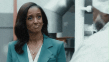 a woman in a blue suit is looking at a man in a white shirt