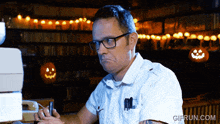 a man sitting at a desk with a gifrun.com watermark on the bottom
